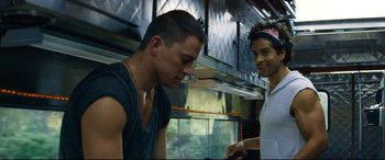 Movie still from “Magic Mike XXL” (2015), directed by Gregory Jacobs – Two people in a kitchen talking to each other; Medium shot, Over the shoulder angle