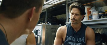 Movie still from “Magic Mike XXL” (2015), directed by Gregory Jacobs – A man in a black tank top talking to another man; Close Up shot, Over the shoulder angle
