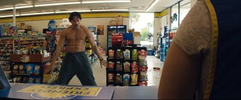 Movie still from “Magic Mike XXL” (2015), directed by Gregory Jacobs – A shirtless man is in a convenience store; Wide shot, Over the shoulder angle
