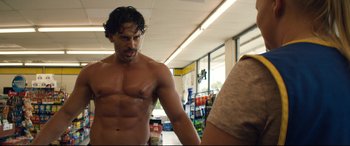 Movie still from “Magic Mike XXL” (2015), directed by Gregory Jacobs – A shirtless man in a store looking at a woman in a tank top; Medium shot, Over the shoulder angle