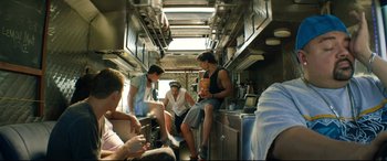 Movie still from “Magic Mike XXL” (2015), directed by Gregory Jacobs – A group of people sitting in a kitchen next to each other; Wide shot, Low angle
