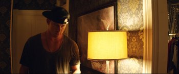 Movie still from “Magic Mike XXL” (2015), directed by Gregory Jacobs – A man standing in front of a lamp in front of a mirror; Medium shot, Low angle