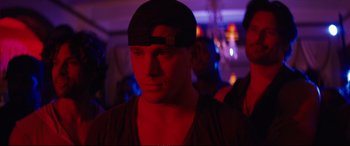Movie still from “Magic Mike XXL” (2015), directed by Gregory Jacobs – A man in a black hat is in a dark room; Close Up shot, Over the shoulder angle