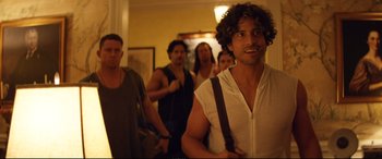 Movie still from “Magic Mike XXL” (2015), directed by Gregory Jacobs – A group of people standing in a room; Medium shot, Over the shoulder angle