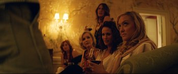 Movie still from “Magic Mike XXL” (2015), directed by Gregory Jacobs – A group of women sitting next to each other holding wine glasses; Medium shot, Over the shoulder angle