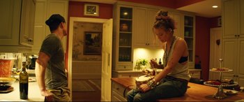 Movie still from “Magic Mike XXL” (2015), directed by Gregory Jacobs – A woman sitting on top of a wooden table; Medium shot, High angle