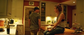 Movie still from “Magic Mike XXL” (2015), directed by Gregory Jacobs – A man and a woman sitting on a kitchen counter; Medium shot, Over the shoulder angle