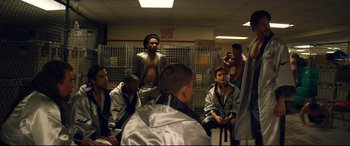 Movie still from “Magic Mike XXL” (2015), directed by Gregory Jacobs – A group of men sitting in front of each other in a room; Medium shot, Over the shoulder angle