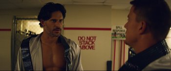 Movie still from “Magic Mike XXL” (2015), directed by Gregory Jacobs – A man standing in front of a do not stack above sign; Medium shot, Over the shoulder angle