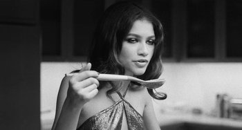Movie still from “Malcolm & Marie” (2021), directed by Sam Levinson – A beautiful young lady holding a tooth brush in her mouth; Close Up shot, High angle