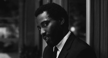 Movie still from “Malcolm & Marie” (2021), directed by Sam Levinson – A black and white photo of a man wearing a suit and tie; Close Up shot, Low angle