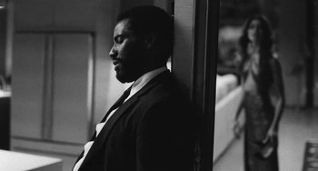 Movie still from “Malcolm & Marie” (2021), directed by Sam Levinson – A black and white photo of a man leaning against a wall; Close Up shot, Over the shoulder angle