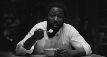 Movie still from “Malcolm & Marie” (2021), directed by Sam Levinson – A black and white photo of a man eating cereal; Close Up shot, Over the shoulder angle