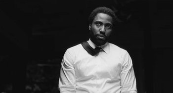 Movie still from “Malcolm & Marie” (2021), directed by Sam Levinson – A black and white photo of a man wearing a shirt and tie; Close Up shot, Low angle