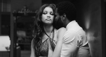 Movie still from “Malcolm & Marie” (2021), directed by Sam Levinson – A man and a woman kissing in front of each other; Medium shot, Low angle
