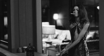 Movie still from “Malcolm & Marie” (2021), directed by Sam Levinson – A black and white photo of a woman smoking a cigarette in front of a mirror; Medium shot, Over the shoulder angle