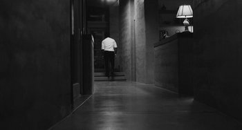 Movie still from “Malcolm & Marie” (2021), directed by Sam Levinson – A man walking down the hall way of a building; Wide shot, Low angle
