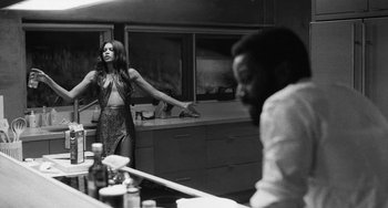 Movie still from “Malcolm & Marie” (2021), directed by Sam Levinson – A woman standing in front of a man in a kitchen; Medium shot, Over the shoulder angle
