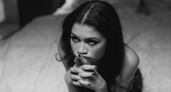 Movie still from “Malcolm & Marie” (2021), directed by Sam Levinson – A beautiful young lady laying on top of a bed; Close Up shot, Overhead angle