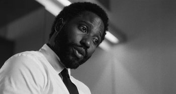 Movie still from “Malcolm & Marie” (2021), directed by Sam Levinson – A black and white photo of a man in a white shirt; Close Up shot, Low angle