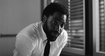 Movie still from “Malcolm & Marie” (2021), directed by Sam Levinson – A black and white photo of a man in a white shirt; Close Up shot, Low angle
