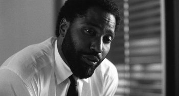 Movie still from “Malcolm & Marie” (2021), directed by Sam Levinson – A black and white photo of a man in a white shirt; Close Up shot, Low angle