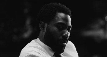 Movie still from “Malcolm & Marie” (2021), directed by Sam Levinson – A black and white photo of a man with a beard; Close Up shot, Low angle