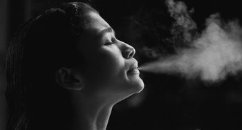 Movie still from “Malcolm & Marie” (2021), directed by Sam Levinson – A black - and - white photo of a woman's face with steam coming out of her mouth; Extreme Close Up shot, Low angle