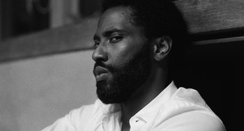 Movie still from “Malcolm & Marie” (2021), directed by Sam Levinson – A black and white photo of a man with a beard; Close Up shot, Low angle