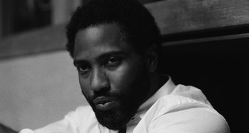 Movie still from “Malcolm & Marie” (2021), directed by Sam Levinson – A black and white photo of a man in a white shirt; Close Up shot, Low angle