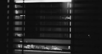 Movie still from “Malcolm & Marie” (2021), directed by Sam Levinson – A black - and - white photo of a table with dishes; Wide shot, Over the shoulder angle
