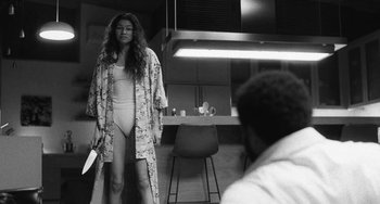 Movie still from “Malcolm & Marie” (2021), directed by Sam Levinson – A black and white photo of a woman in a robe; Medium shot, Over the shoulder angle