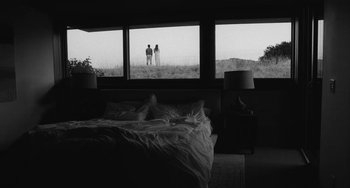 Movie still from “Malcolm & Marie” (2021), directed by Sam Levinson – Two people are standing in a bedroom looking out the window; Wide shot, Low angle