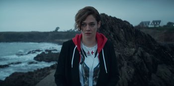 Movie still from “Marianne” (2019), created by Samuel Bodin – A woman standing in front of some rocks; Close Up shot, High angle