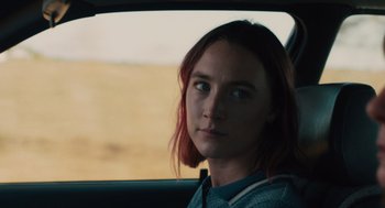 Movie still from “Lady Bird” (2017), directed by Greta Gerwig – A woman sitting in the back seat of a car; Close Up shot, Over the shoulder angle