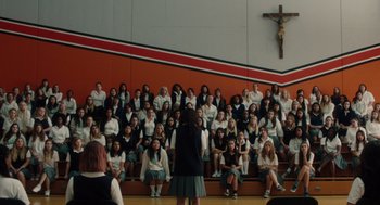 Movie still from “Lady Bird” (2017), directed by Greta Gerwig – A large group of people sitting in front of a cross; Extreme Wide shot, High angle