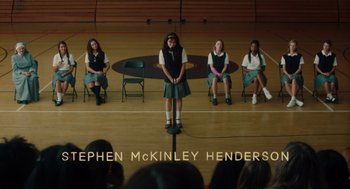 Movie still from “Lady Bird” (2017), directed by Greta Gerwig – A group of young women sitting on chairs in a gymnasium; Extreme Wide shot, High angle