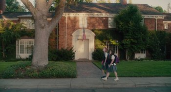 Movie still from “Lady Bird” (2017), directed by Greta Gerwig – A couple of people that are walking down the sidewalk; Extreme Wide shot, Low angle