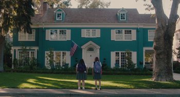 Movie still from “Lady Bird” (2017), directed by Greta Gerwig – Two young girls standing in front of a blue house; Extreme Wide shot, Low angle