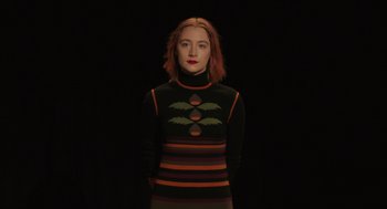 Movie still from “Lady Bird” (2017), directed by Greta Gerwig – A woman with red hair wearing a black and orange sweater; Medium shot, Low angle