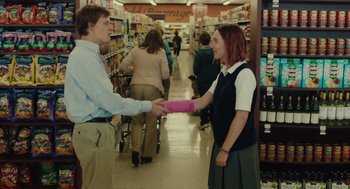 Movie still from “Lady Bird” (2017), directed by Greta Gerwig – A man and a woman shaking hands in a grocery store; Medium shot, Over the shoulder angle