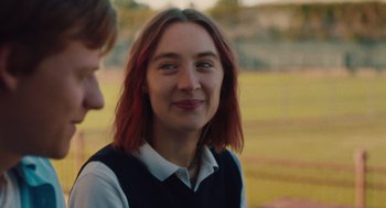 Movie still from “Lady Bird” (2017), directed by Greta Gerwig – A woman with long red hair is smiling at the camera; Close Up shot, Over the shoulder angle