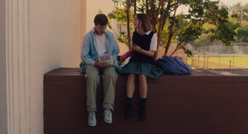 Movie still from “Lady Bird” (2017), directed by Greta Gerwig – A man and a woman sitting next to each other on a ledge; Medium shot, Over the shoulder angle