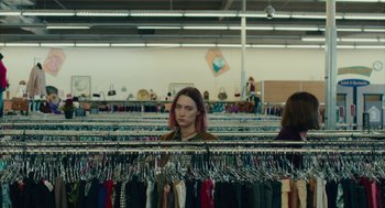 Movie still from “Lady Bird” (2017), directed by Greta Gerwig – A woman is looking at clothes on a rack; Medium shot, Over the shoulder angle