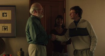 Movie still from “Lady Bird” (2017), directed by Greta Gerwig – Two men and a woman shaking hands in front of a door; Medium shot, Over the shoulder angle