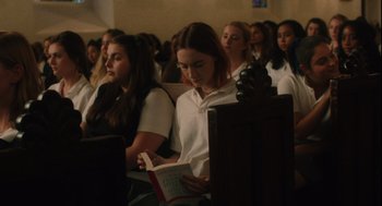 Movie still from “Lady Bird” (2017), directed by Greta Gerwig – A group of young people sitting in a room; Medium shot, High angle