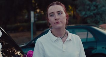 Movie still from “Lady Bird” (2017), directed by Greta Gerwig – A woman in a white shirt is standing in front of a car; Close Up shot, Over the shoulder angle