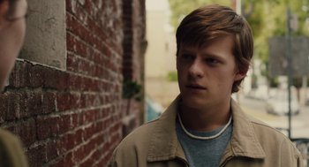 Movie still from “Lady Bird” (2017), directed by Greta Gerwig – A young man standing in front of a red brick wall; Close Up shot, Over the shoulder angle