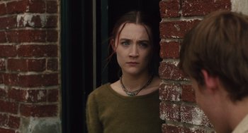 Movie still from “Lady Bird” (2017), directed by Greta Gerwig – A young woman standing in front of a brick wall; Close Up shot, Over the shoulder angle
