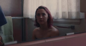 Movie still from “Lady Bird” (2017), directed by Greta Gerwig – A woman with pink hair looking in a mirror; Medium shot, Over the shoulder angle
